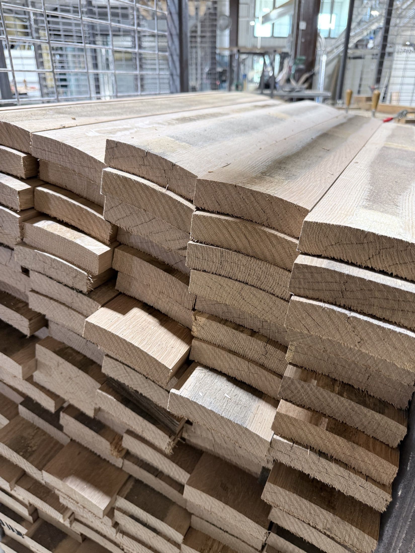Shaped white oak staves stacked inside the Standard Cooperage shop